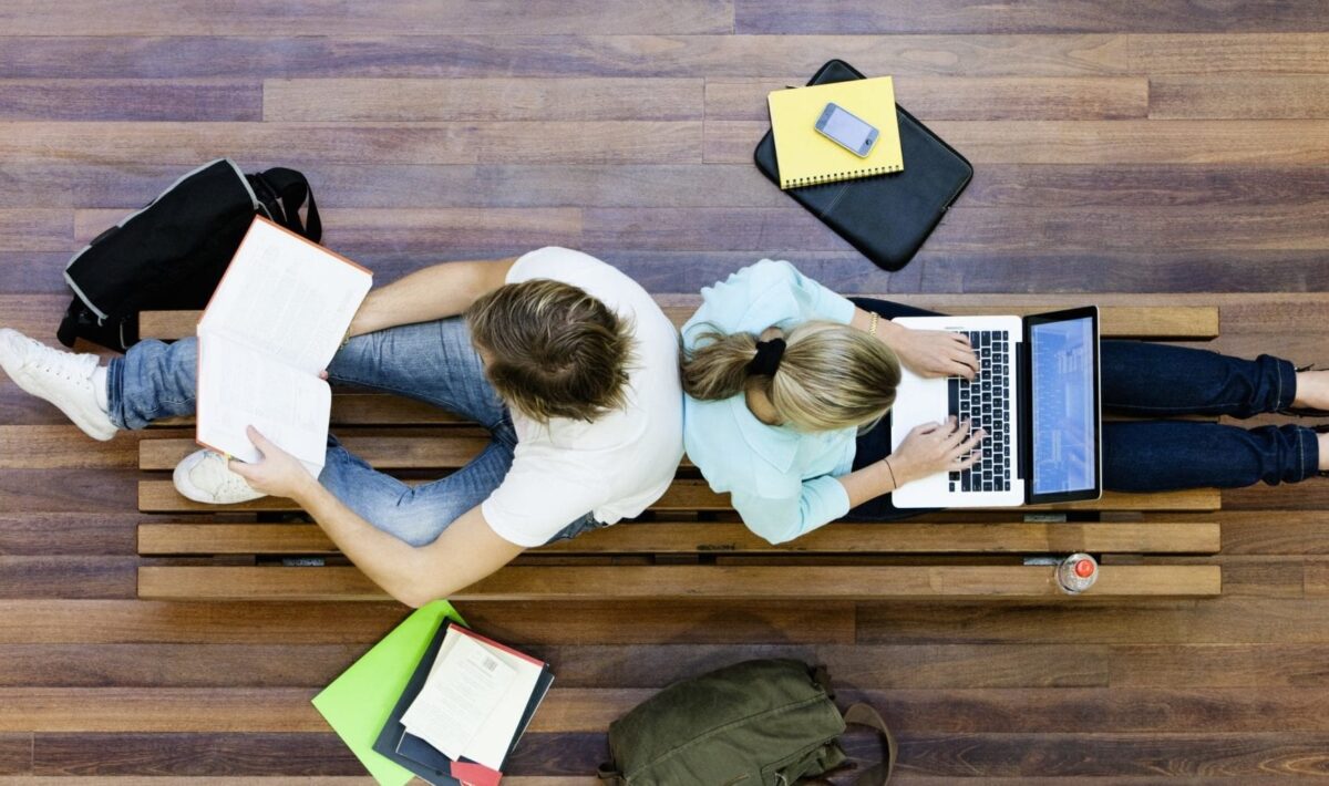 Two people using laptops together