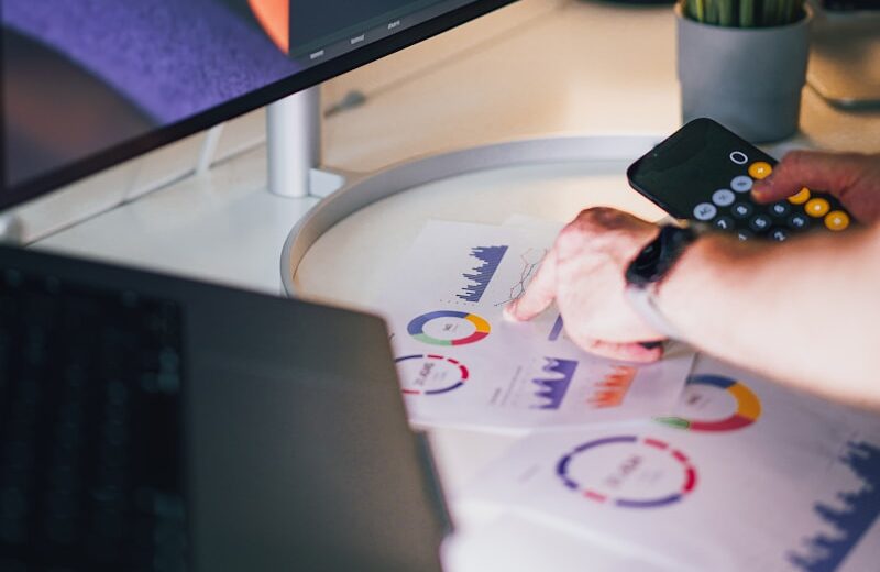 a person holding a remote control in front of a computer screen
